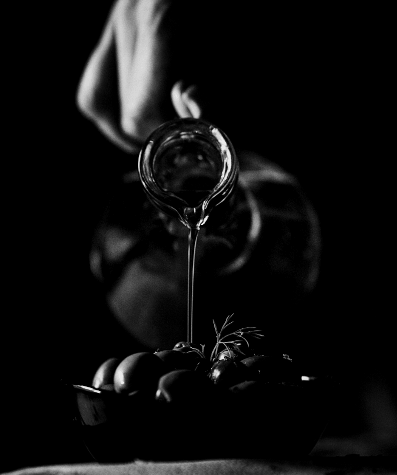 Olive oil being poured over fresh olives